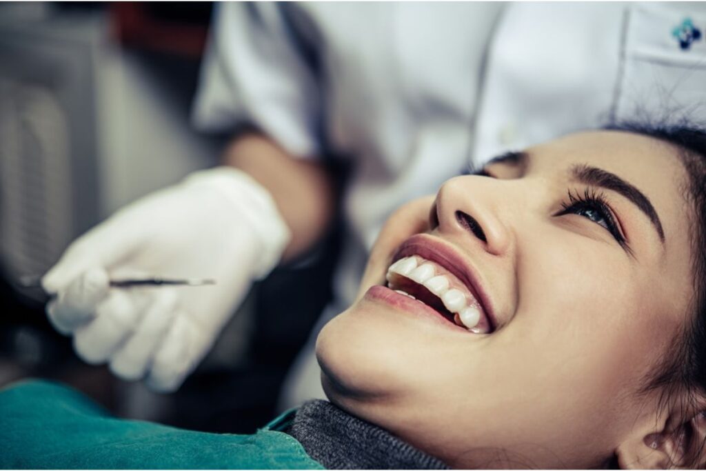 Patient smiling during dental examination at Huntley dental practice.