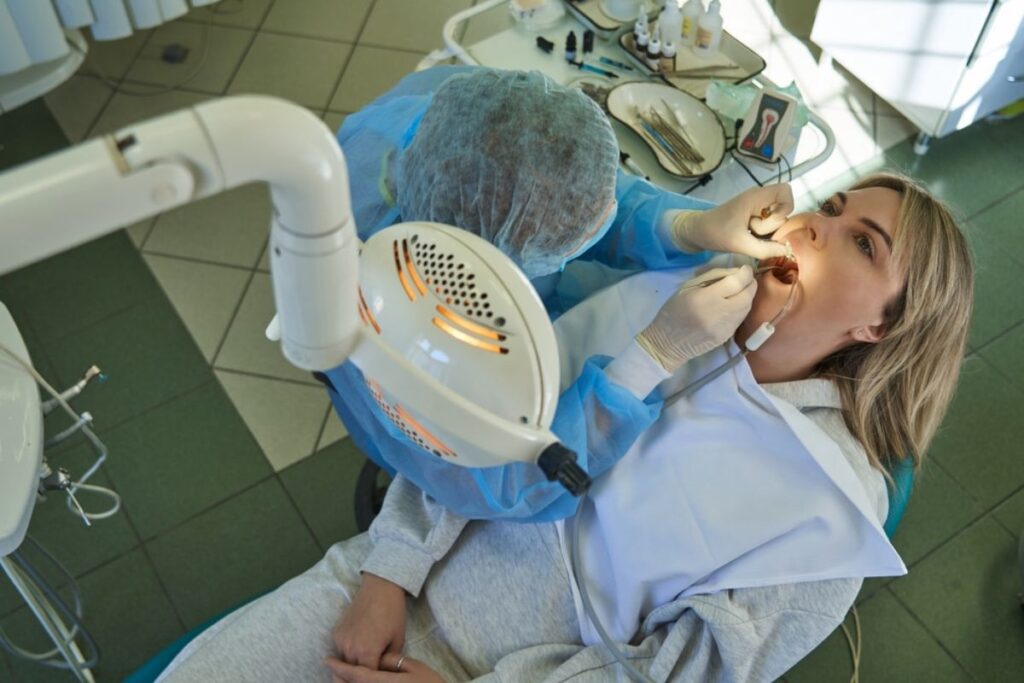 Dentist examining patient's teeth during emergency dental treatment in Huntley.
