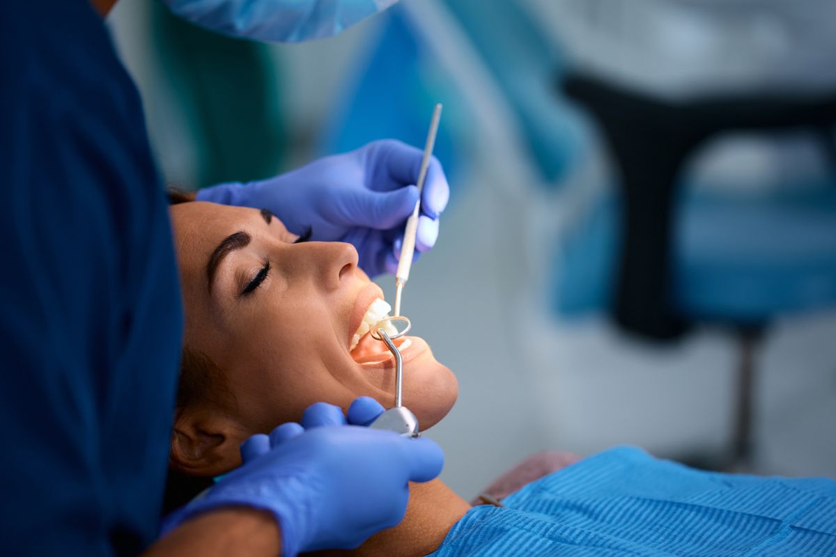 Dentist examining patient’s gums during checkup.