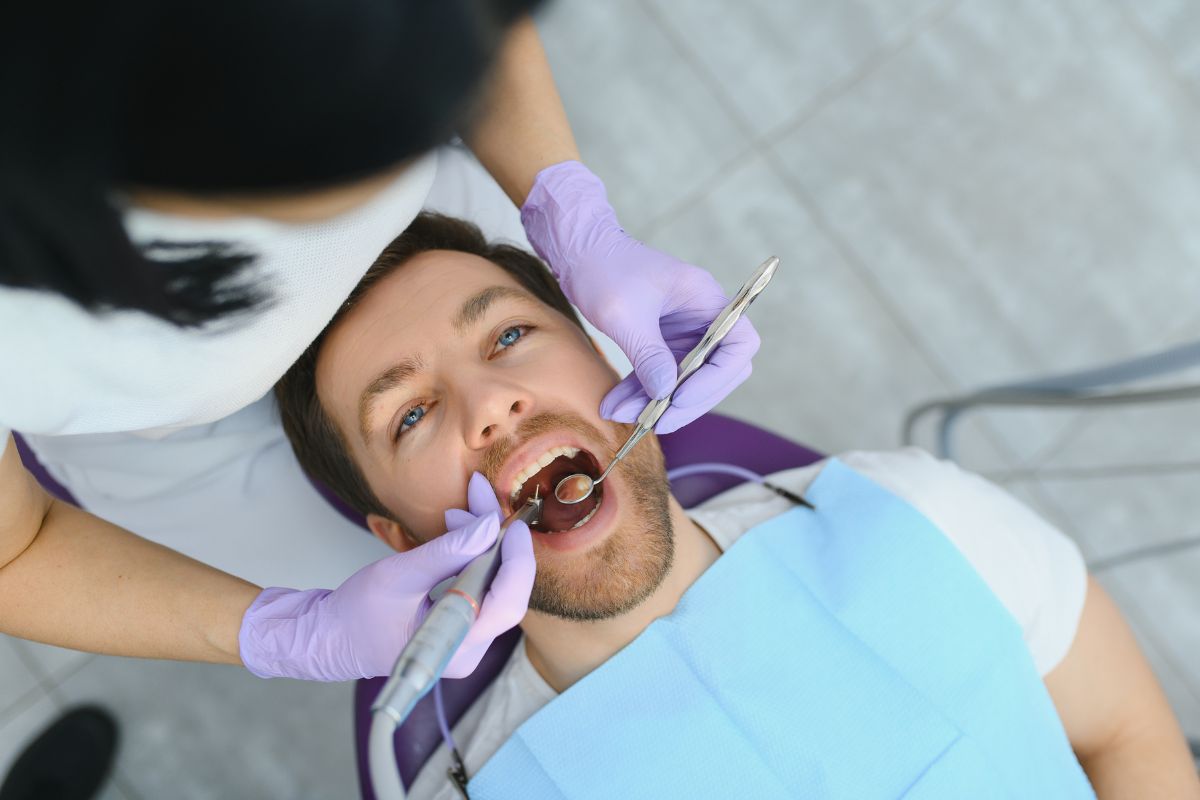 Dentist performing a root canal procedure on a patient in a clinical setting.