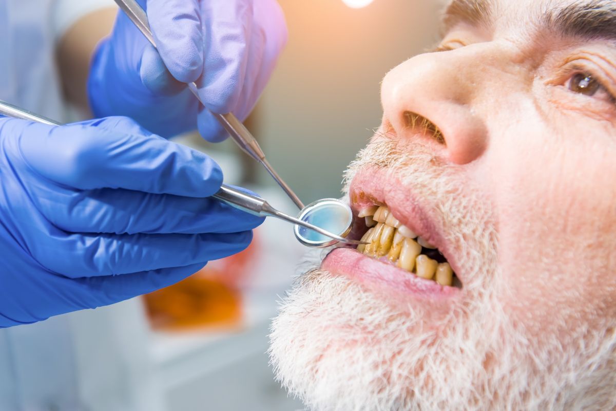 Older adult receiving dental exam to assess age-related changes in teeth and gum health.
