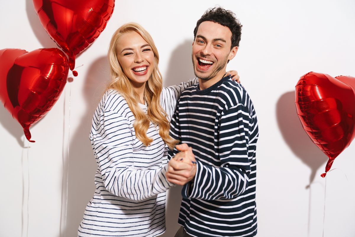 Couple smiling confidently on Valentine's Day with healthy white teeth.