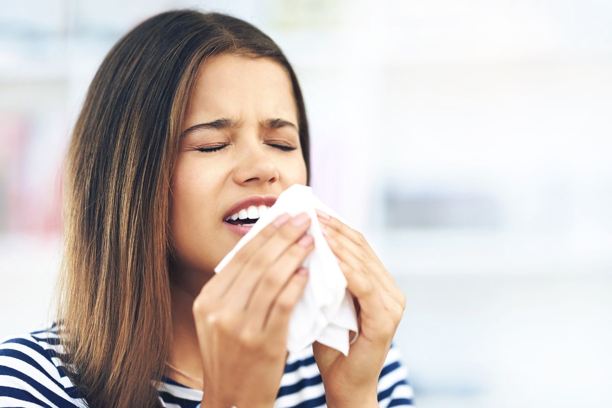 A woman experiencing seasonal allergies with nasal congestion that may contribute to dry mouth and oral health concerns.