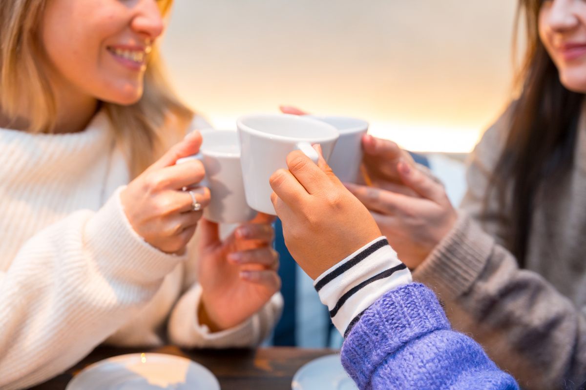 Friends enjoying coffee together while discussing safe teeth whitening options for preventing coffee-related tooth stains.