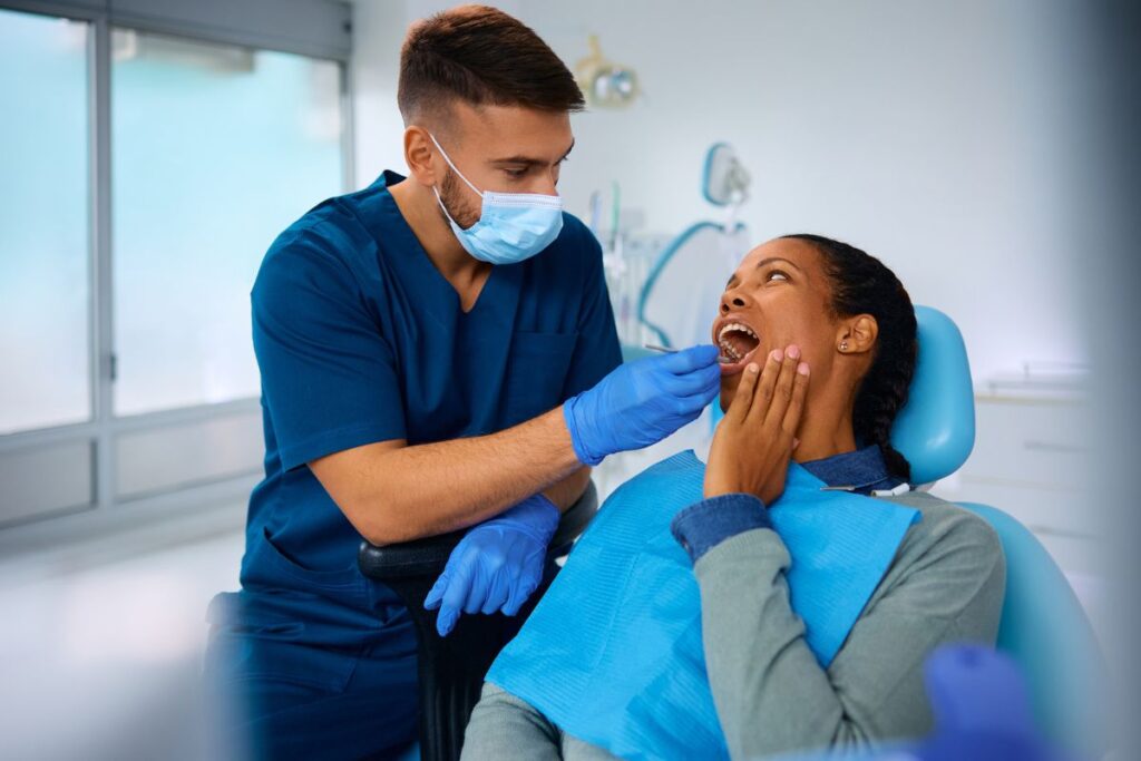 Patient experiencing sudden tooth pain during a dental examination.