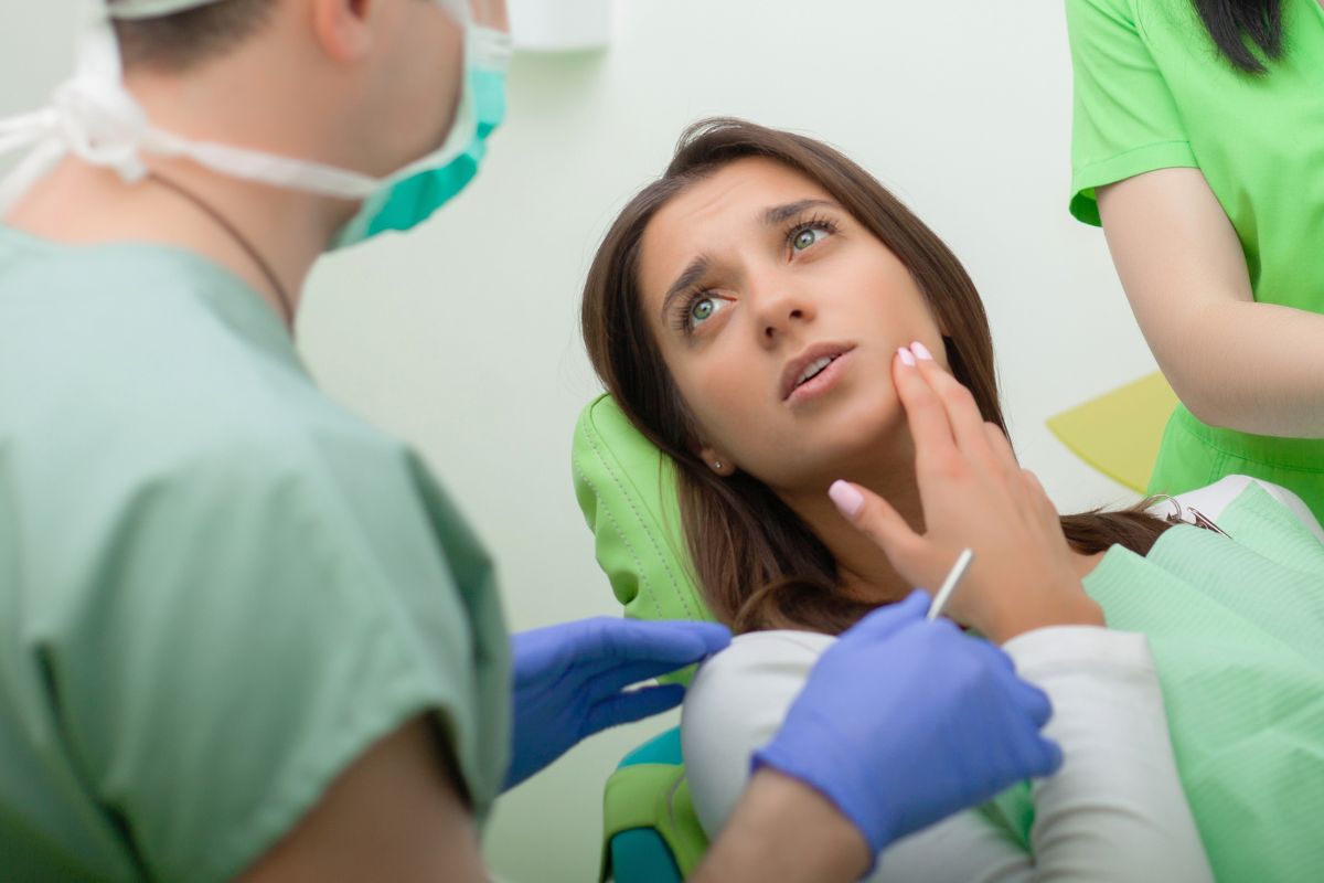 Patient holding jaw due to severe toothache.
